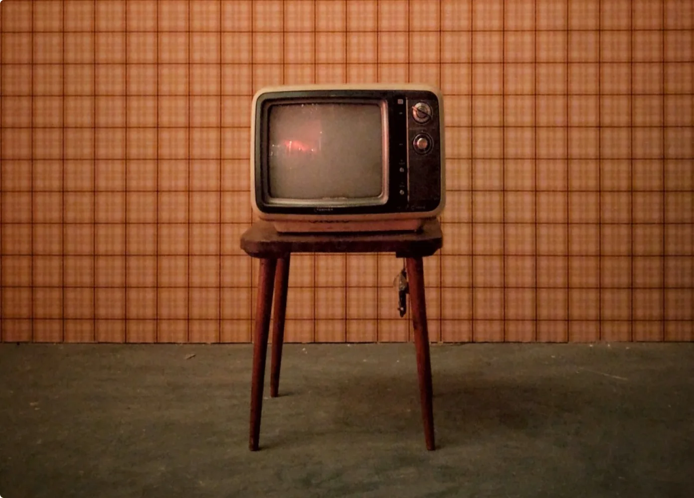 Ein alter Fernseher auf einem TV-Tisch.