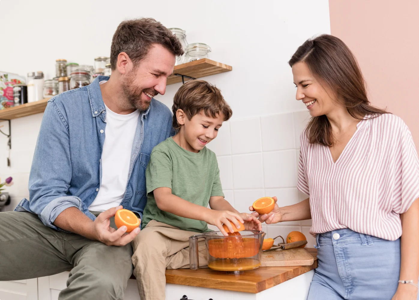 Eine Familie bereitet in der Küche Orangensaft zu