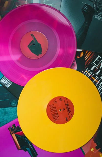 Mehrere bunte Wu-Tang Clan Schallplatten auf einem Tisch.