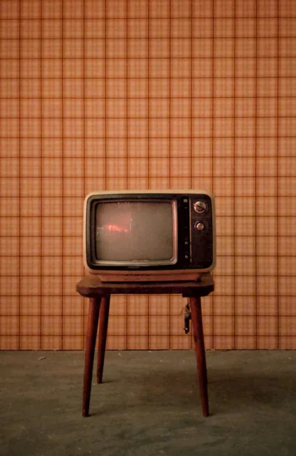 Ein alter Fernseher auf einem TV-Tisch.