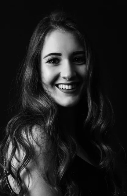 Lächelnde Frau mit langen Haaren in Schwarz-Weiß-Fotografie